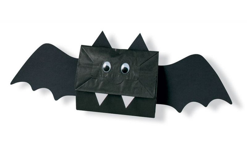 Crafted paper bat with googly eyes and sharp teeth for Halloween decoration.